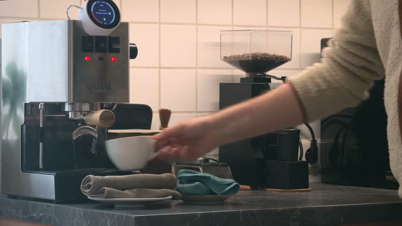 Placing a cup under my Gaggia Classic with Gaggimate, beside the Eureka Mignon in my kitchen
