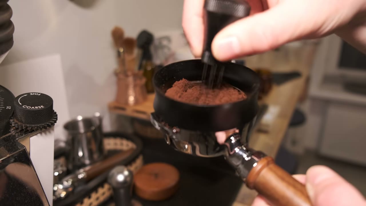 Using a needle WDT tool to distribute coffee inside a portafilter with a dosing funnel