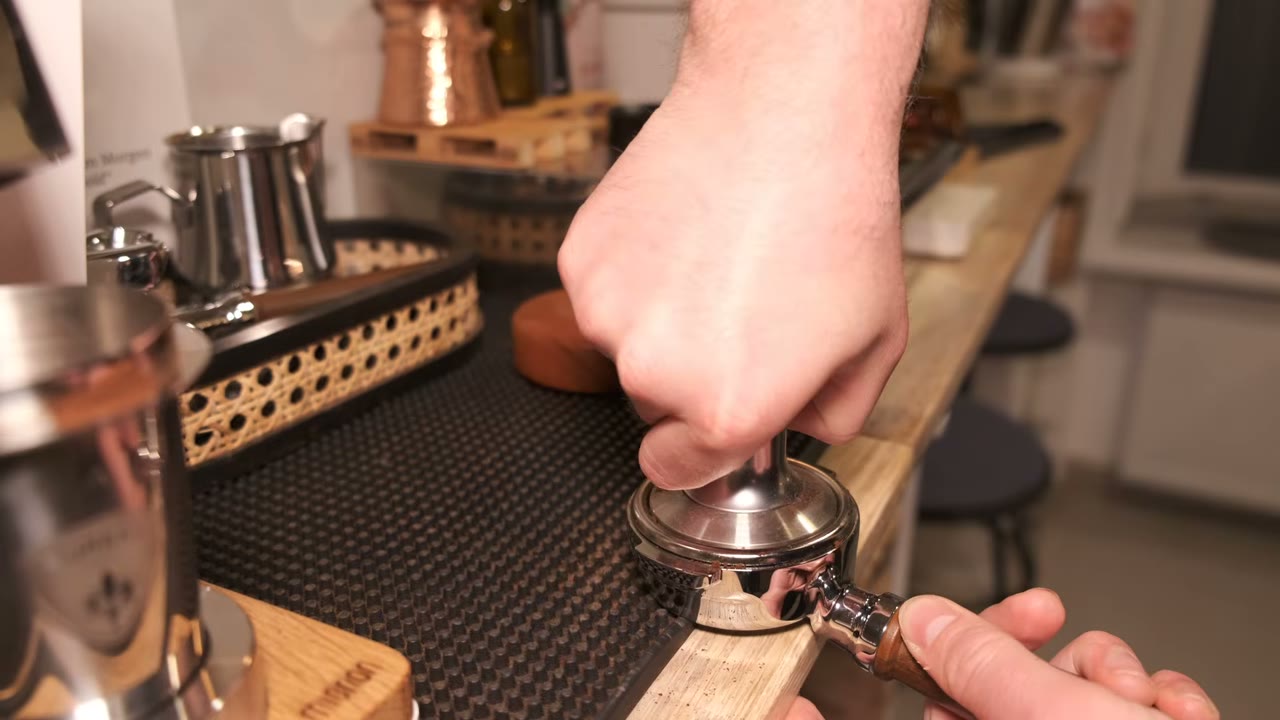 Tamping coffee with the portafilter supported on a rubber mat
